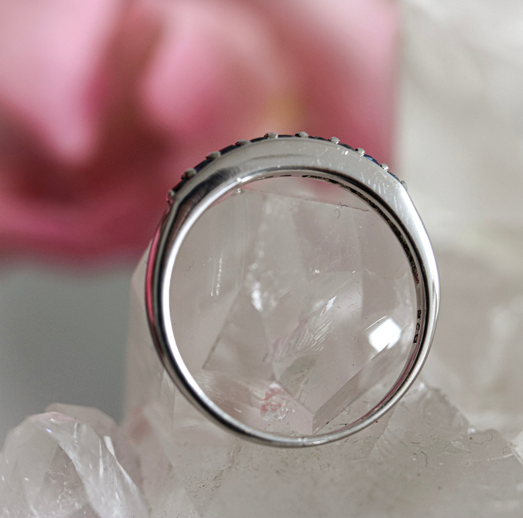 Silver ring with a blue sapphire on a white background
