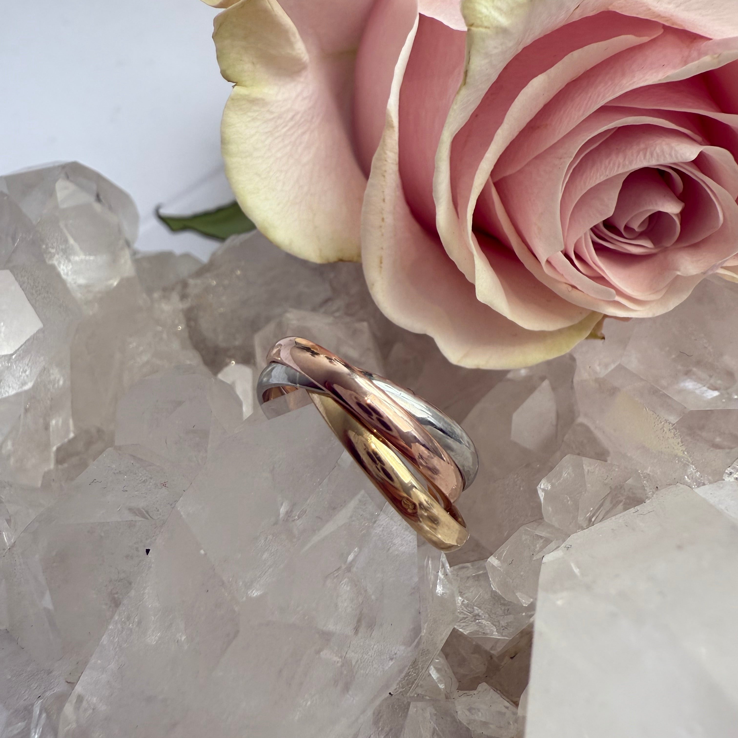 Pink rose and gold ring on a crystal background
