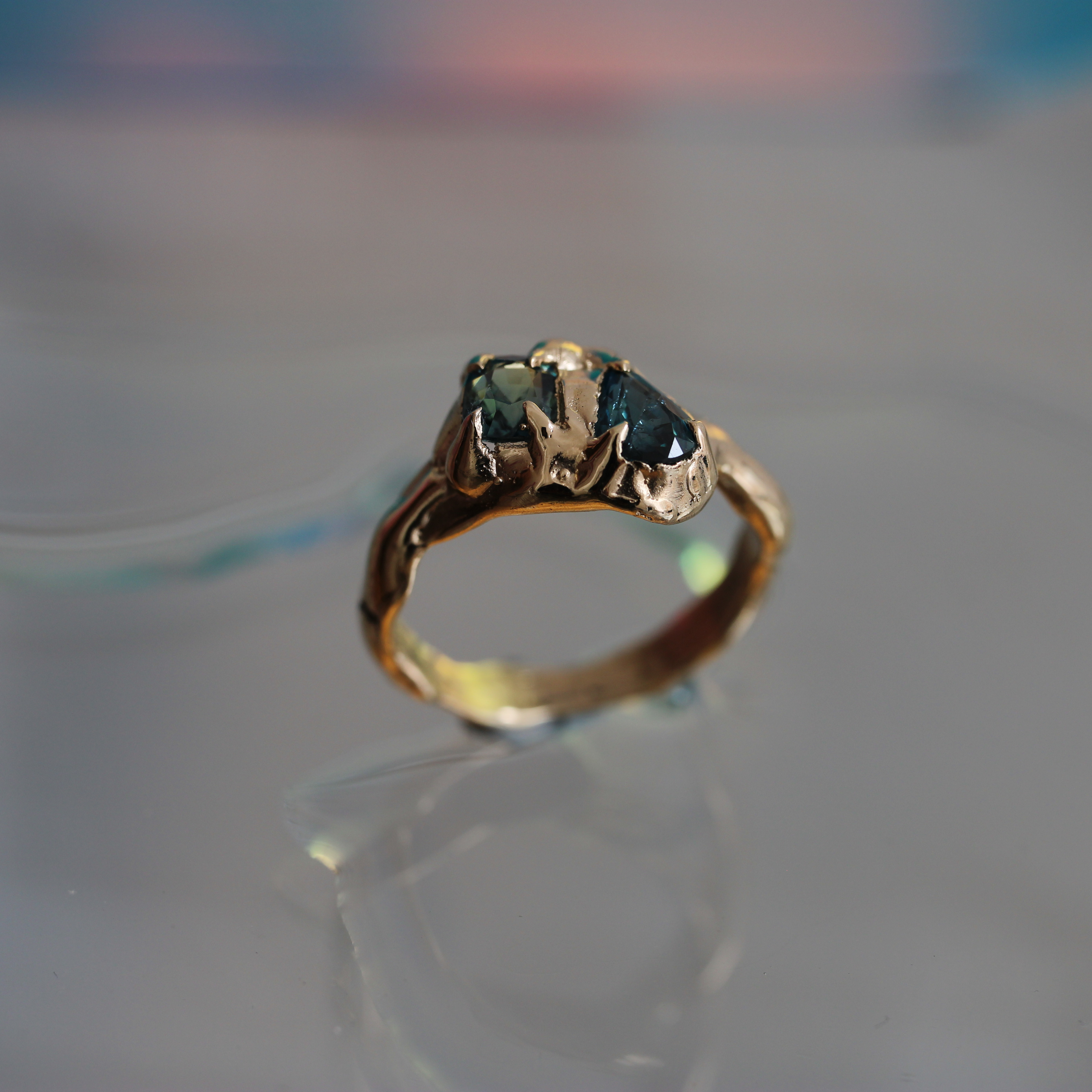 Gold ring with a green sapphire
gemstone on a reflective surface