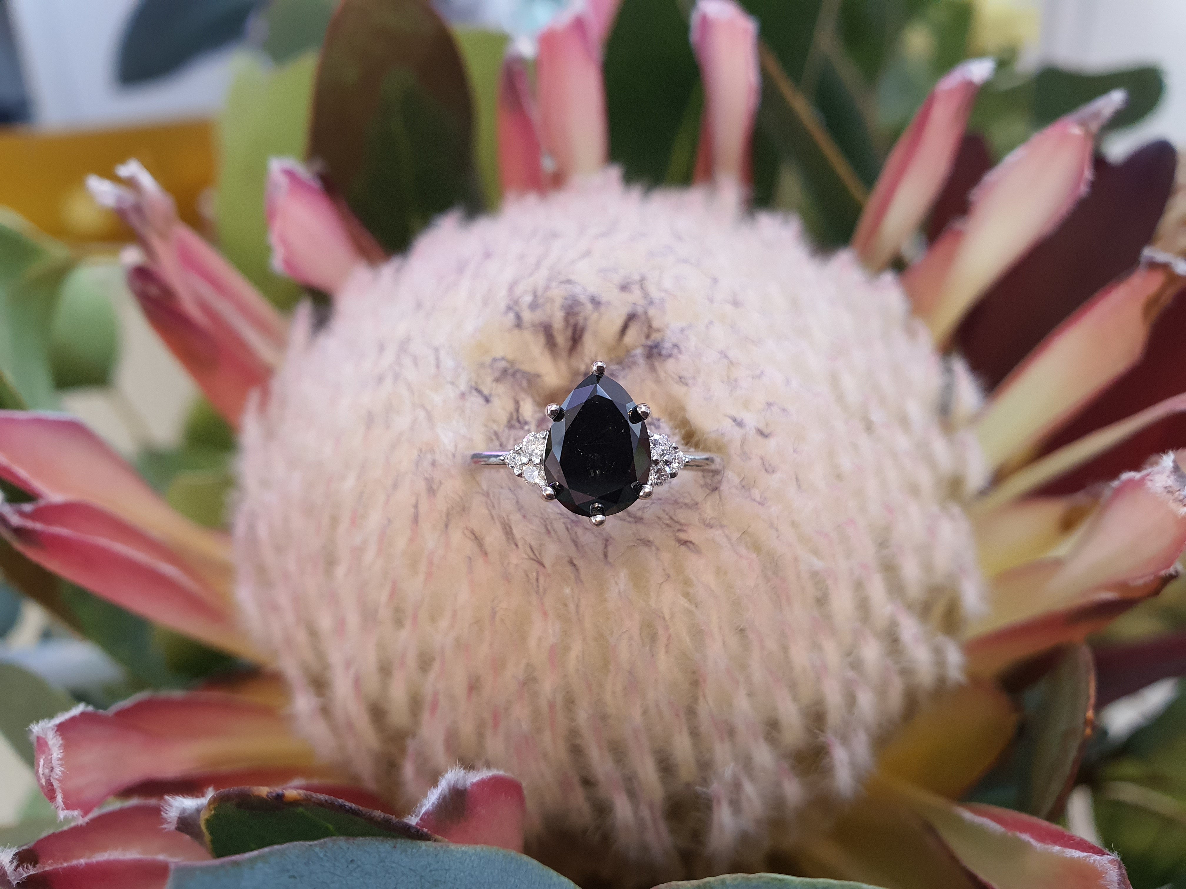 blackdiamond-ring-pear-cut-rose-gold-on flower