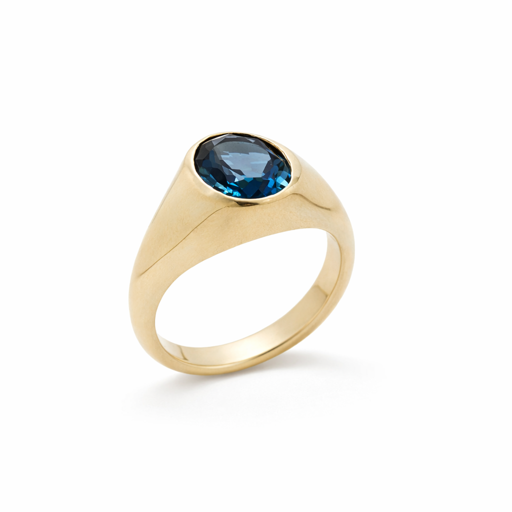 Gold ring with a london blue topaz on a white background