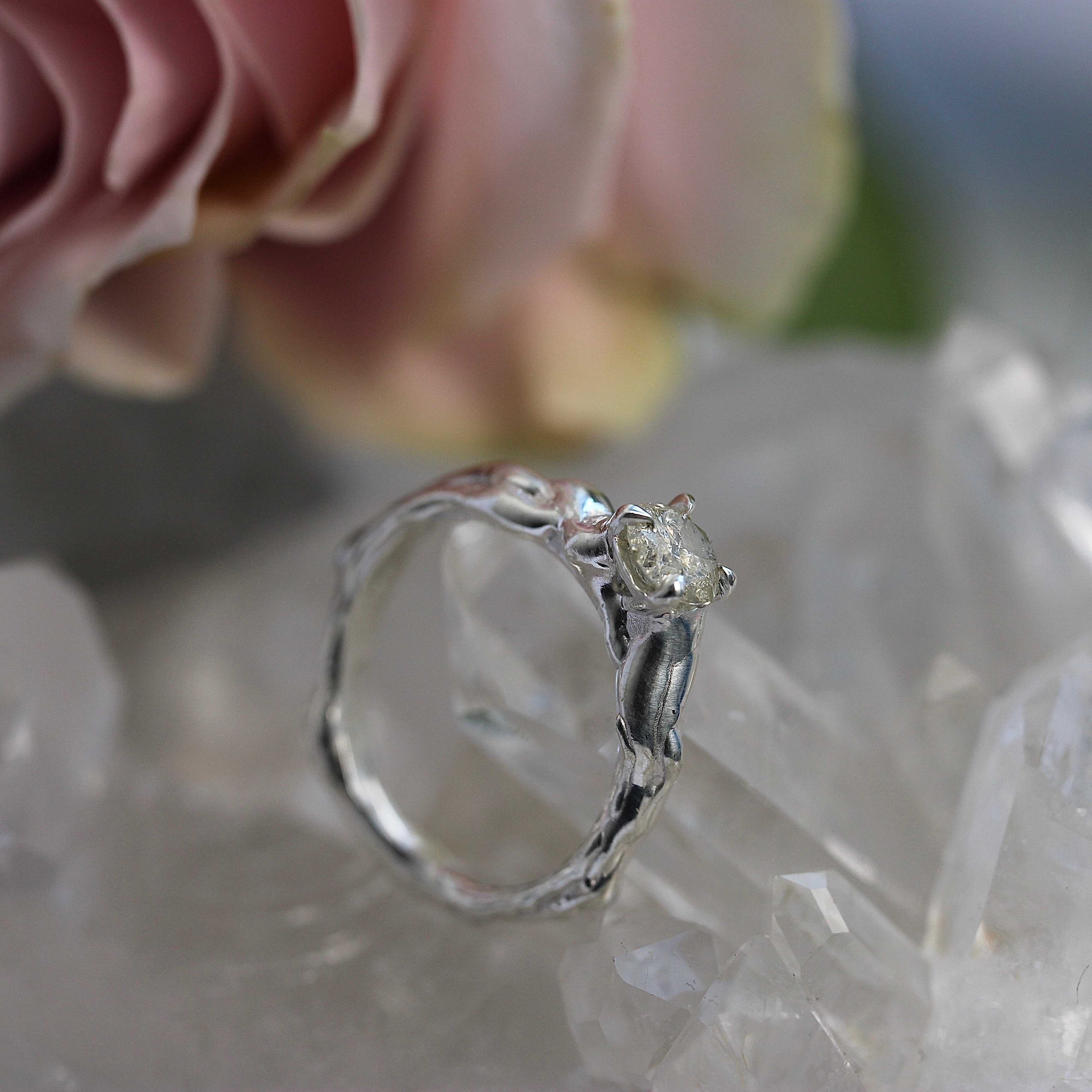 Silver ring with a diamond on a soft focus background