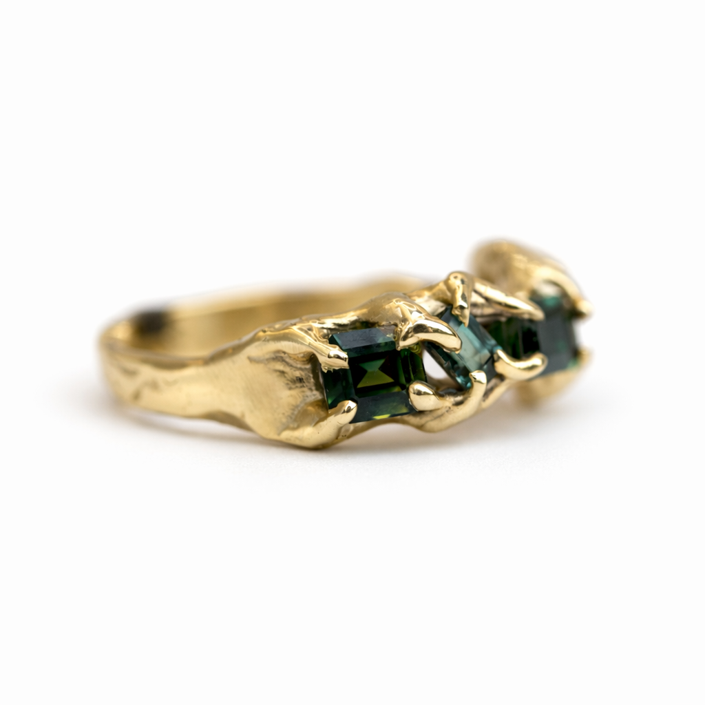 Gold ring with green australian sapphires on a white background