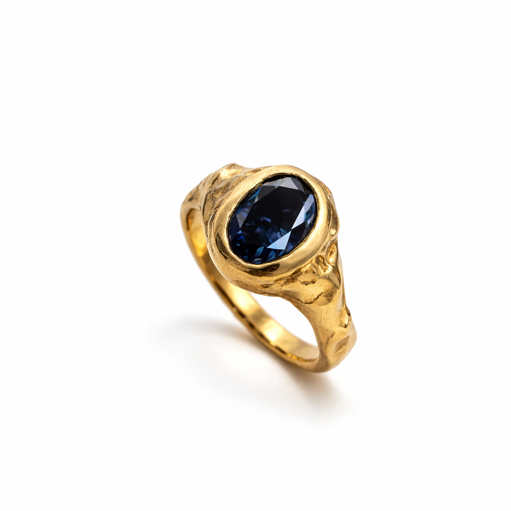Gold ring with a blue gemstone on a white background