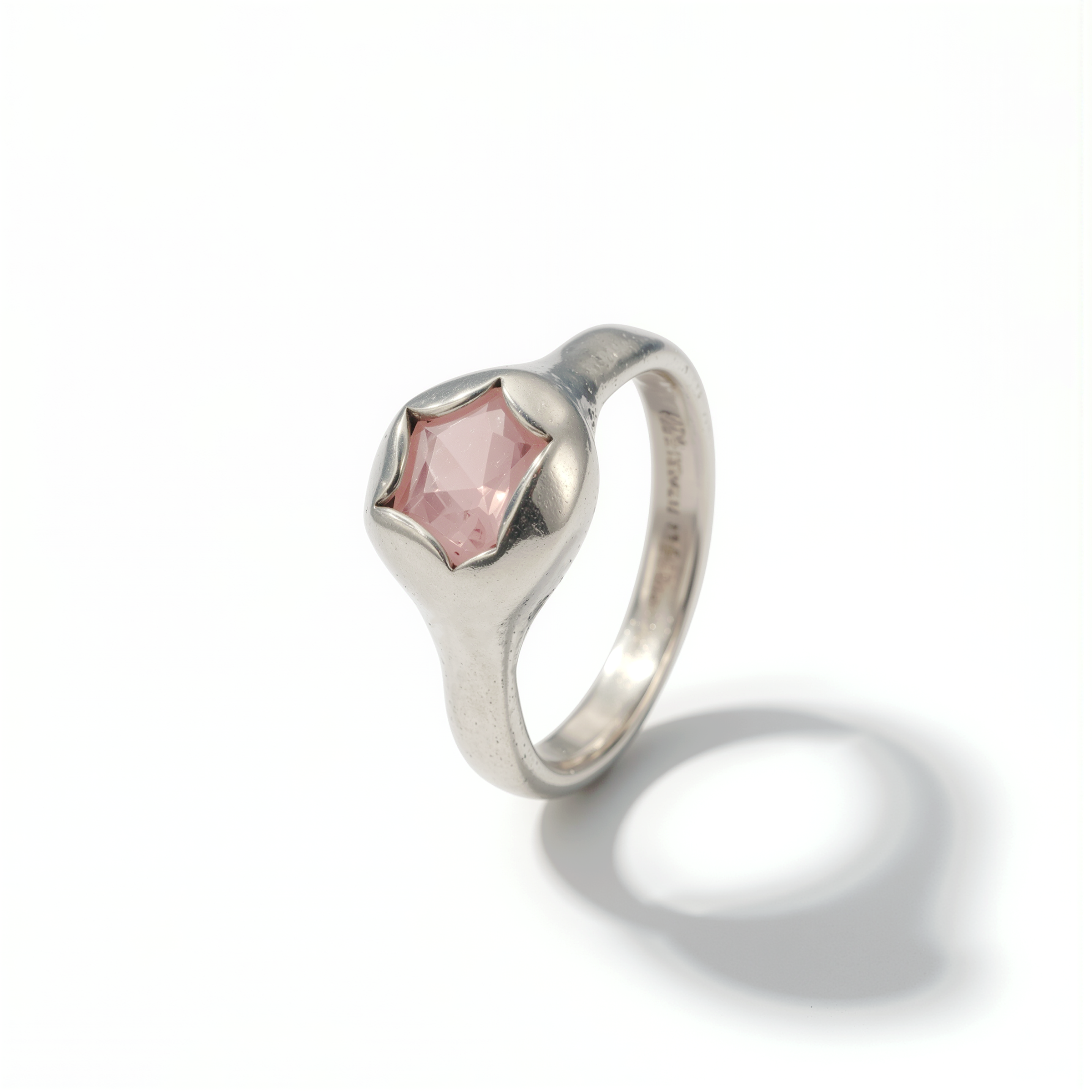 Silver ring with a pink gemstone on a white background