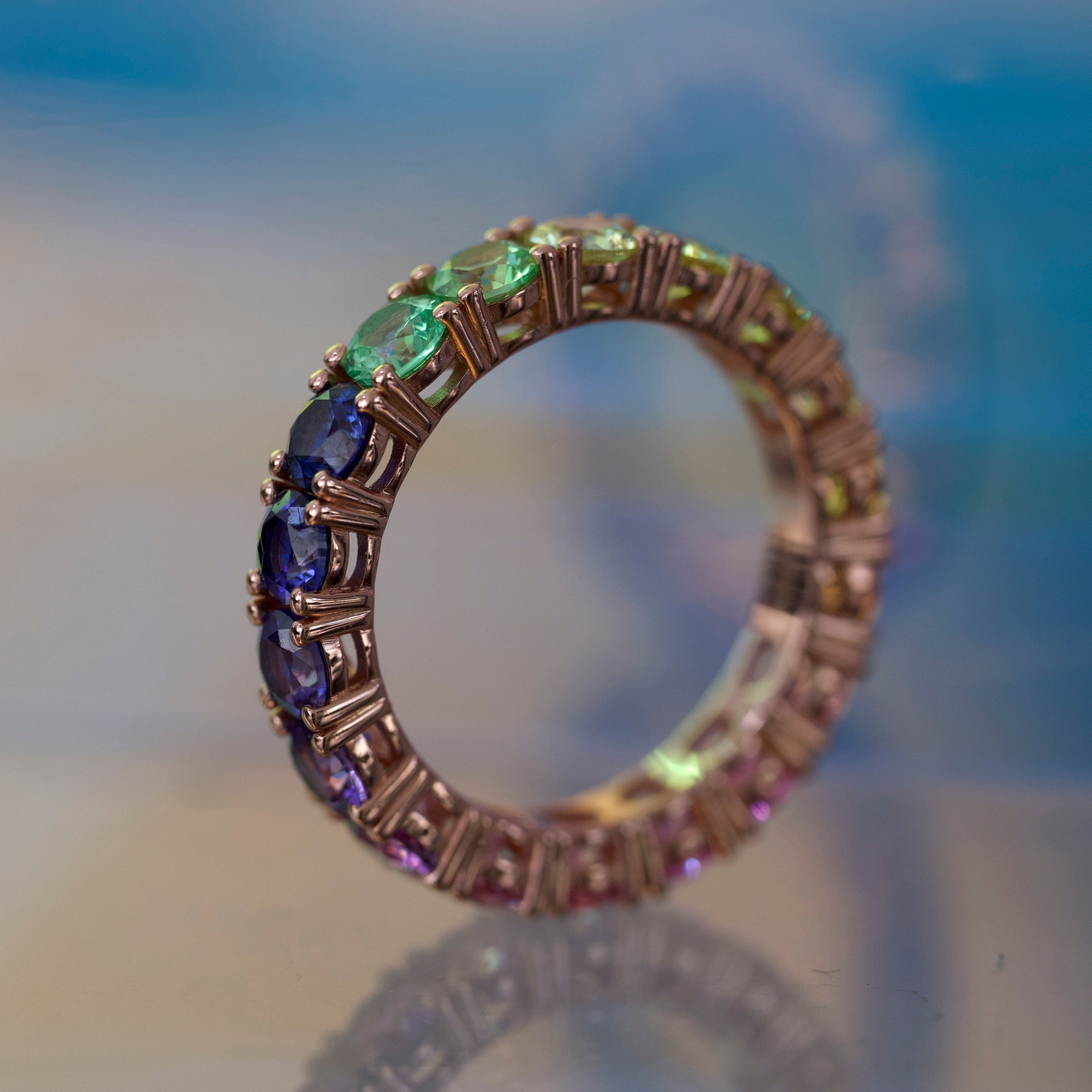 Ring with multicolored gemstones on a blurred background