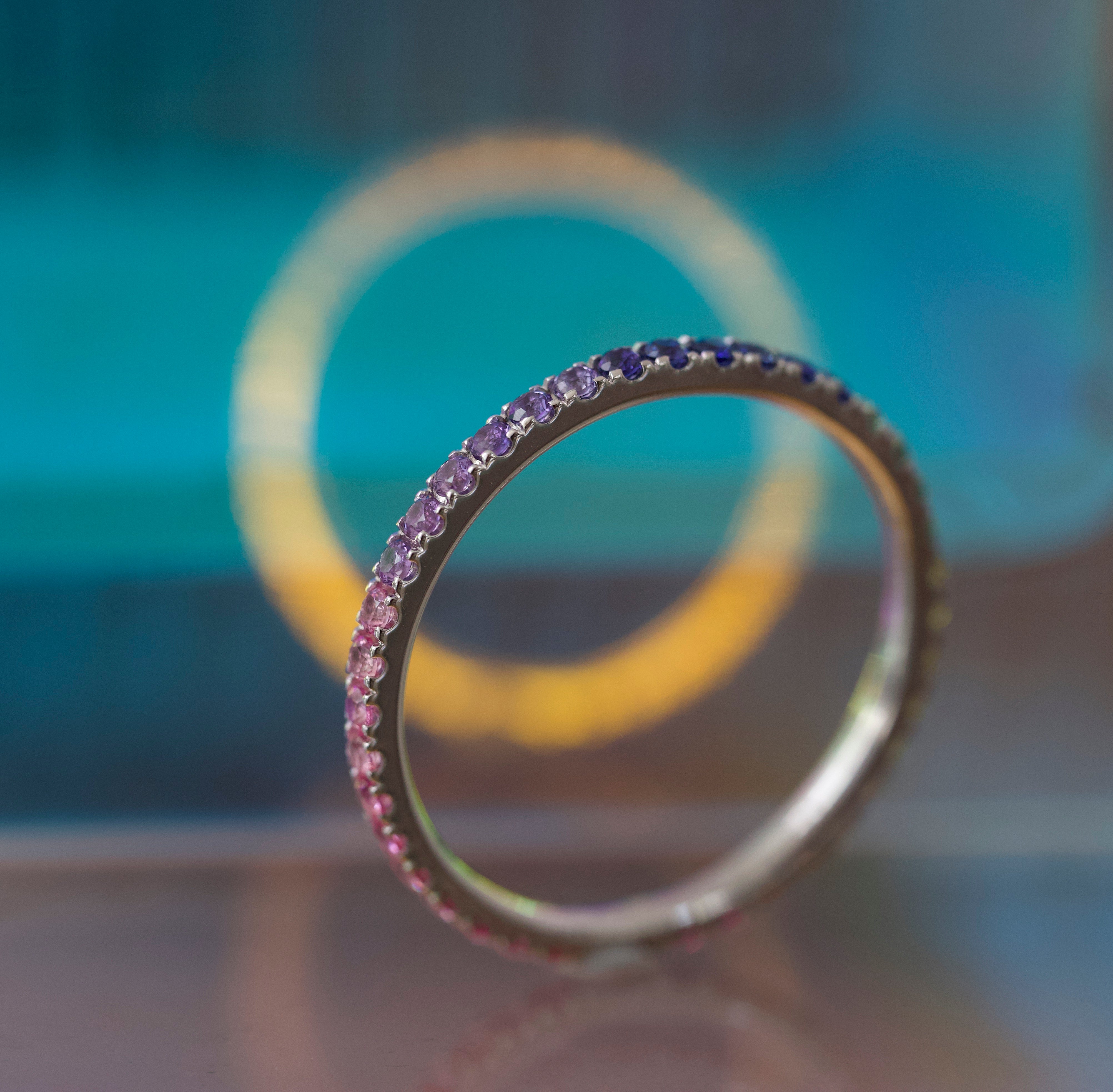 Close-up of a ring with purple gemstones against a blurred background