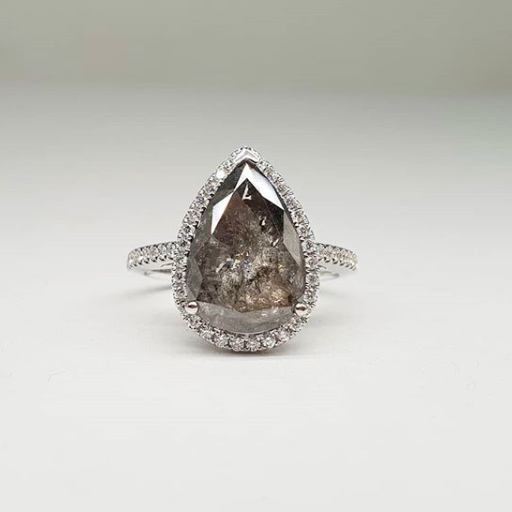 Pear halo diamond engagement ring paired with matching wedding band shown on white background — classic bridal set in rose gold