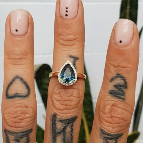 Pear halo sapphire engagement ring shown on hand — classic bridal set in white gold