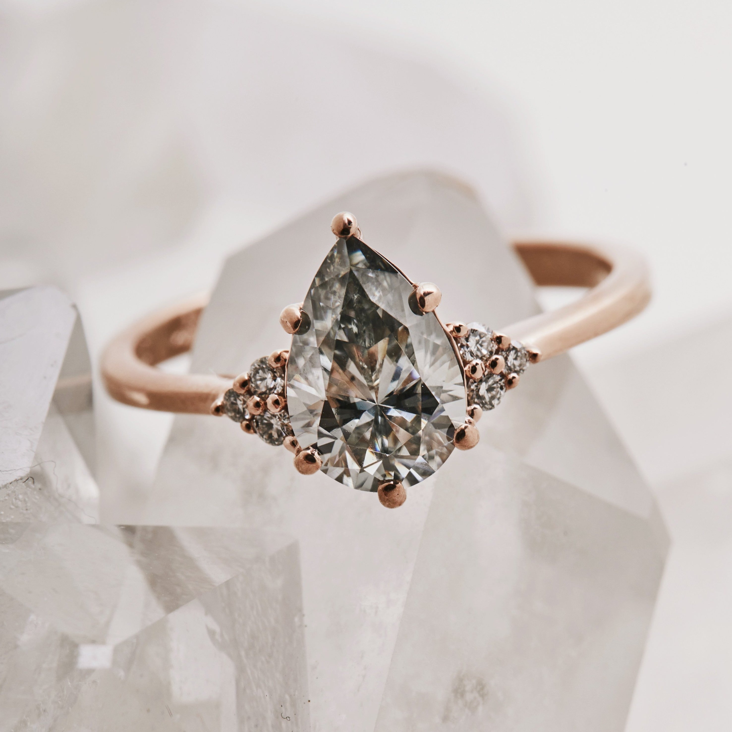 Pear-cut salt and pepper diamond engagement ring in rose gold with side stones