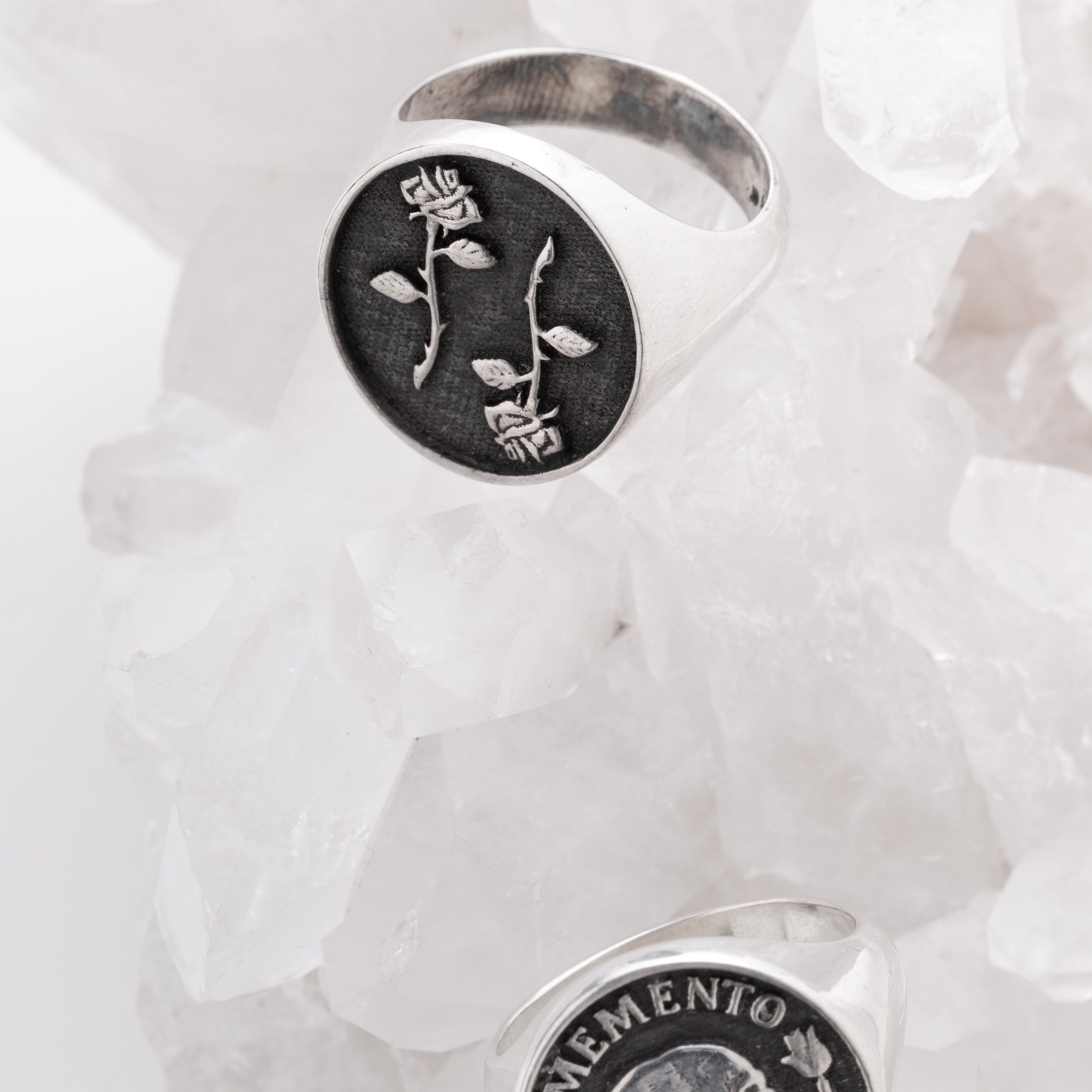 Two silver rings with engraved designs on a white background