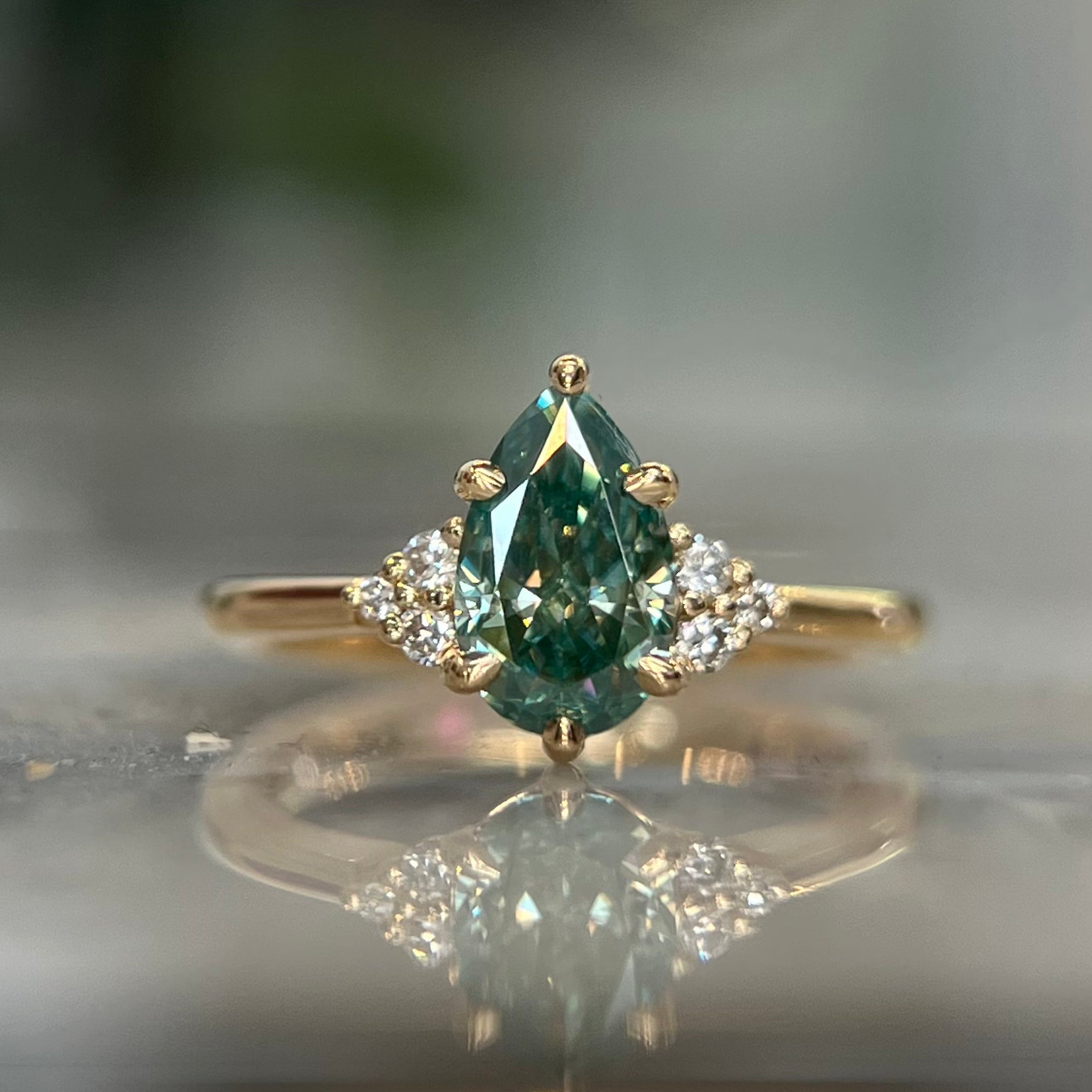 green moissanite-ring-pear-cut-rose-gold-angled-view