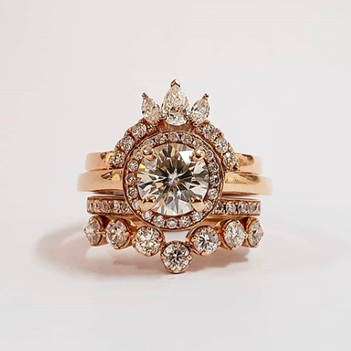 Rose gold halo diamond engagement ring with a thicker pavé band displayed on clean white background — romantic bridal jewellery photo