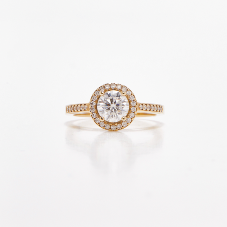 Round halo diamond engagement ring in yellow gold with a thicker pavé band, photographed on a clean white background — elegant bridal jewelry