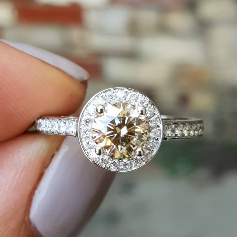 Rose gold halo diamond engagement ring with a thicker pavé band displayed on clean white background — romantic bridal jewellery photo