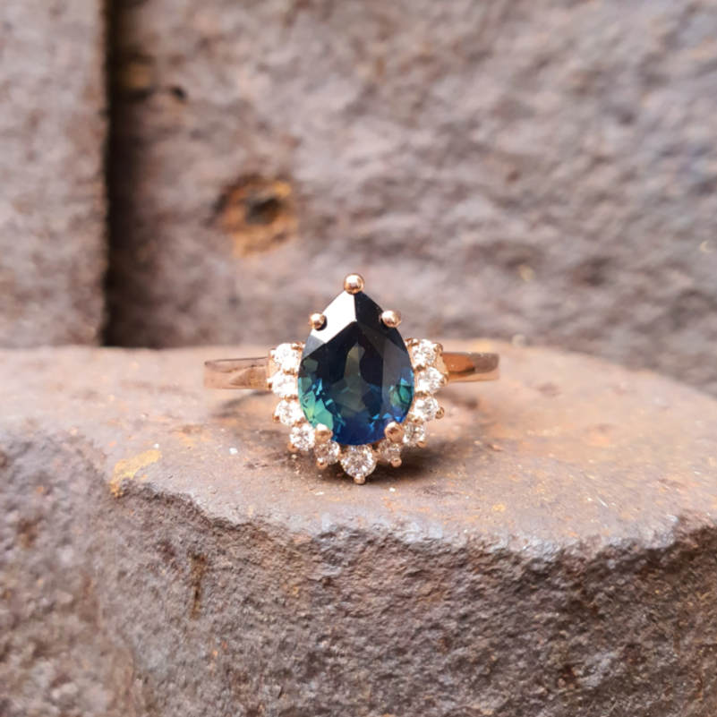 pear amina engagement ring with half halo of white diamonds partii sapphire and rose gold