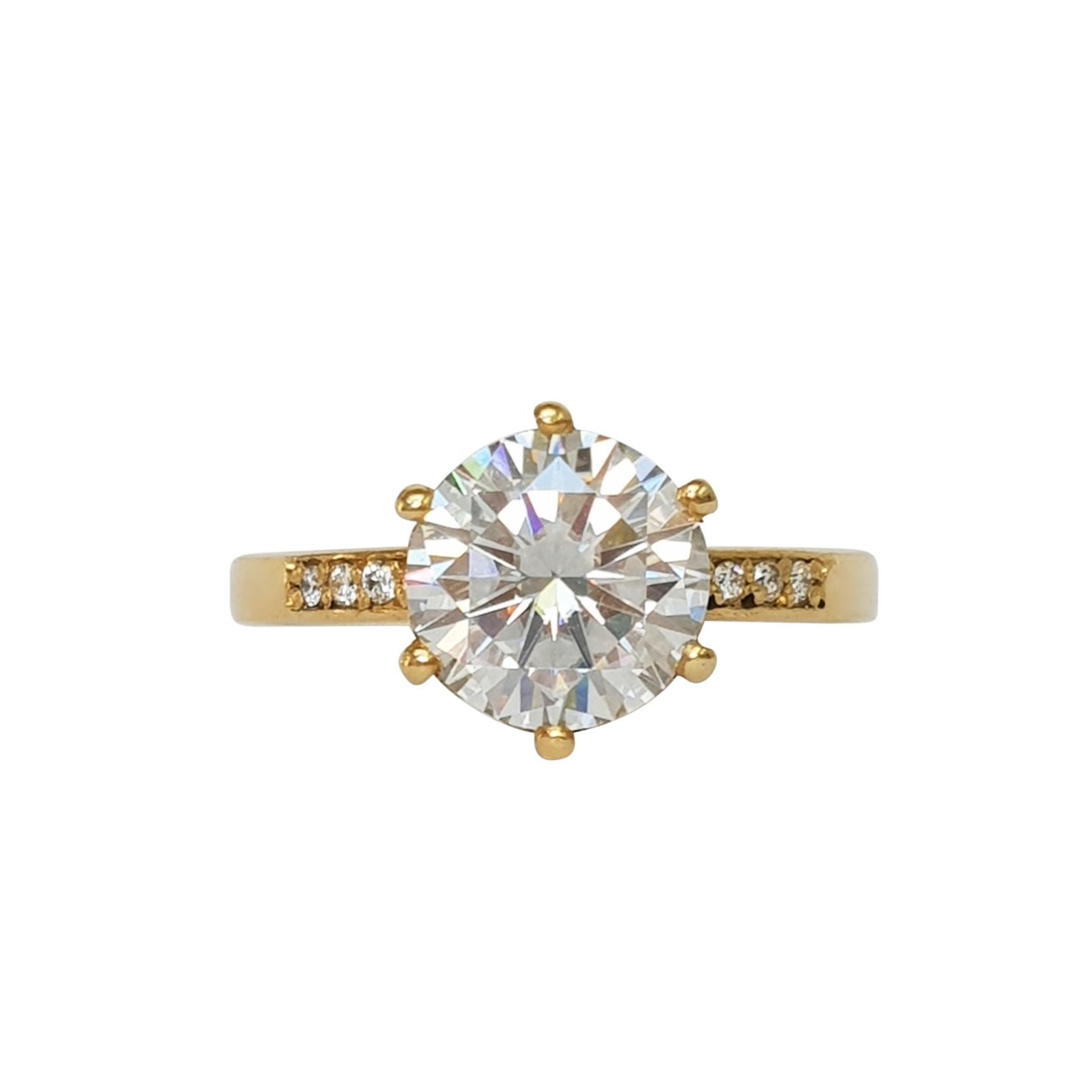 A yellow gold band ring with a central moissanite stone and accent white diamonds set in a ring.