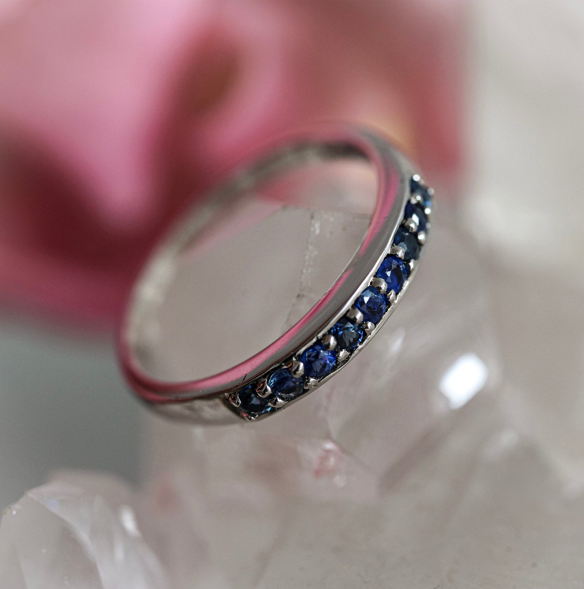 Silver ring with blue sapphire gemstones on a white surface