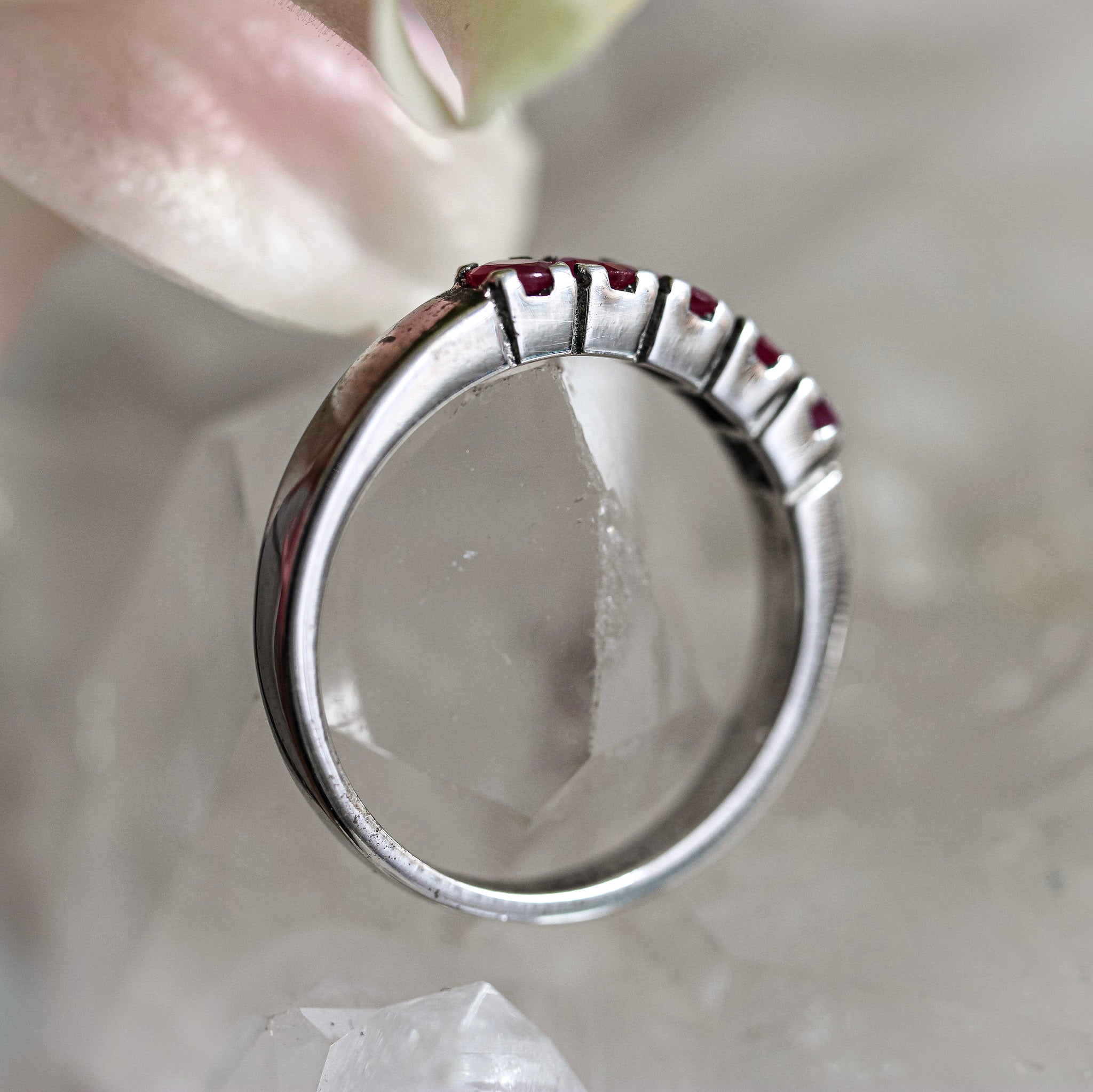 Silver ring with red ruby stones on a soft background