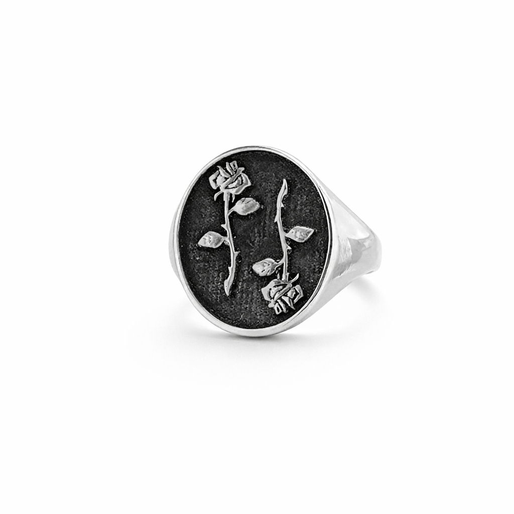 Silver ring with engraved tattoo rose design on a white background