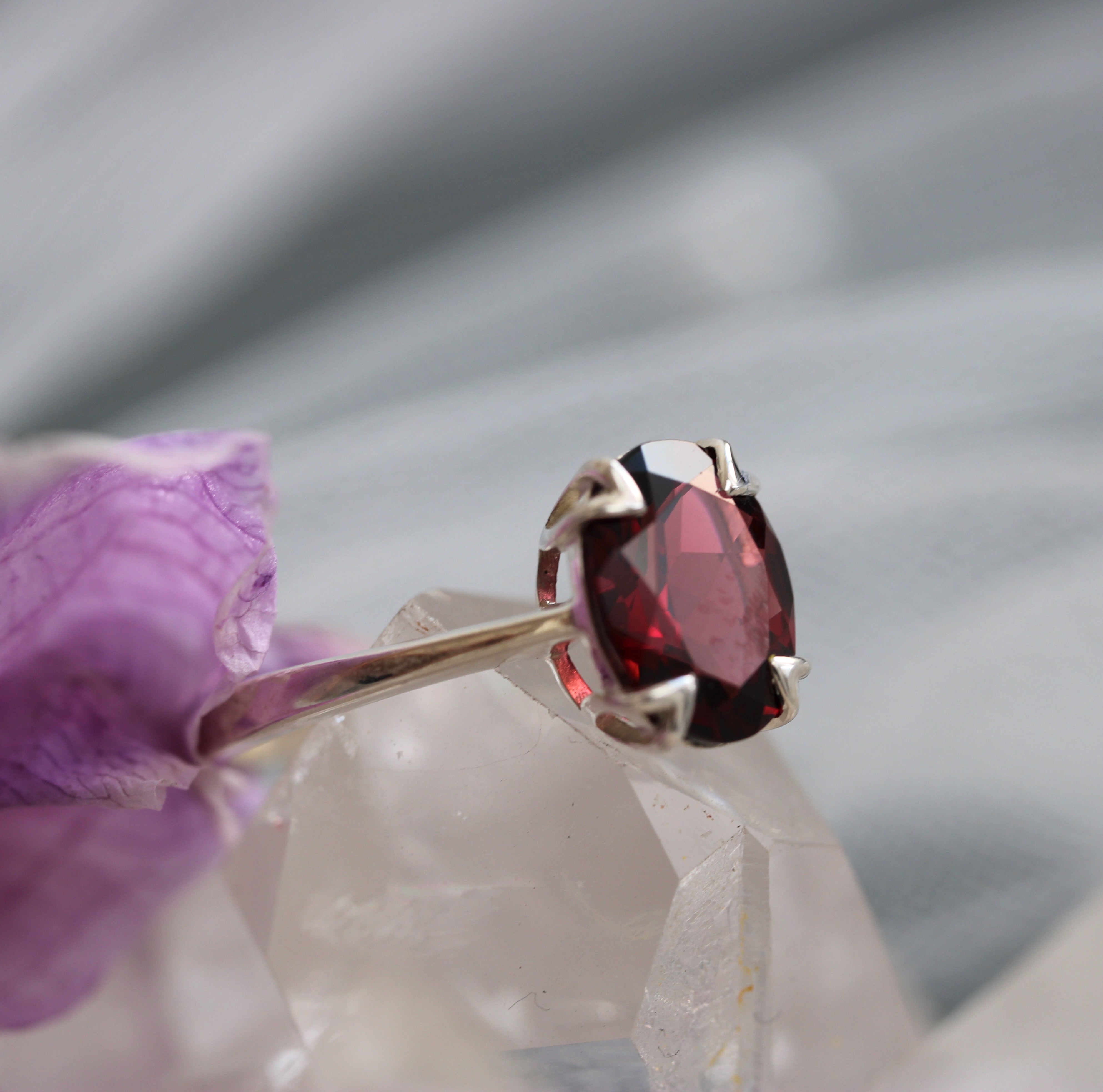 Ring with a red garnet gemstone on a soft fabric background