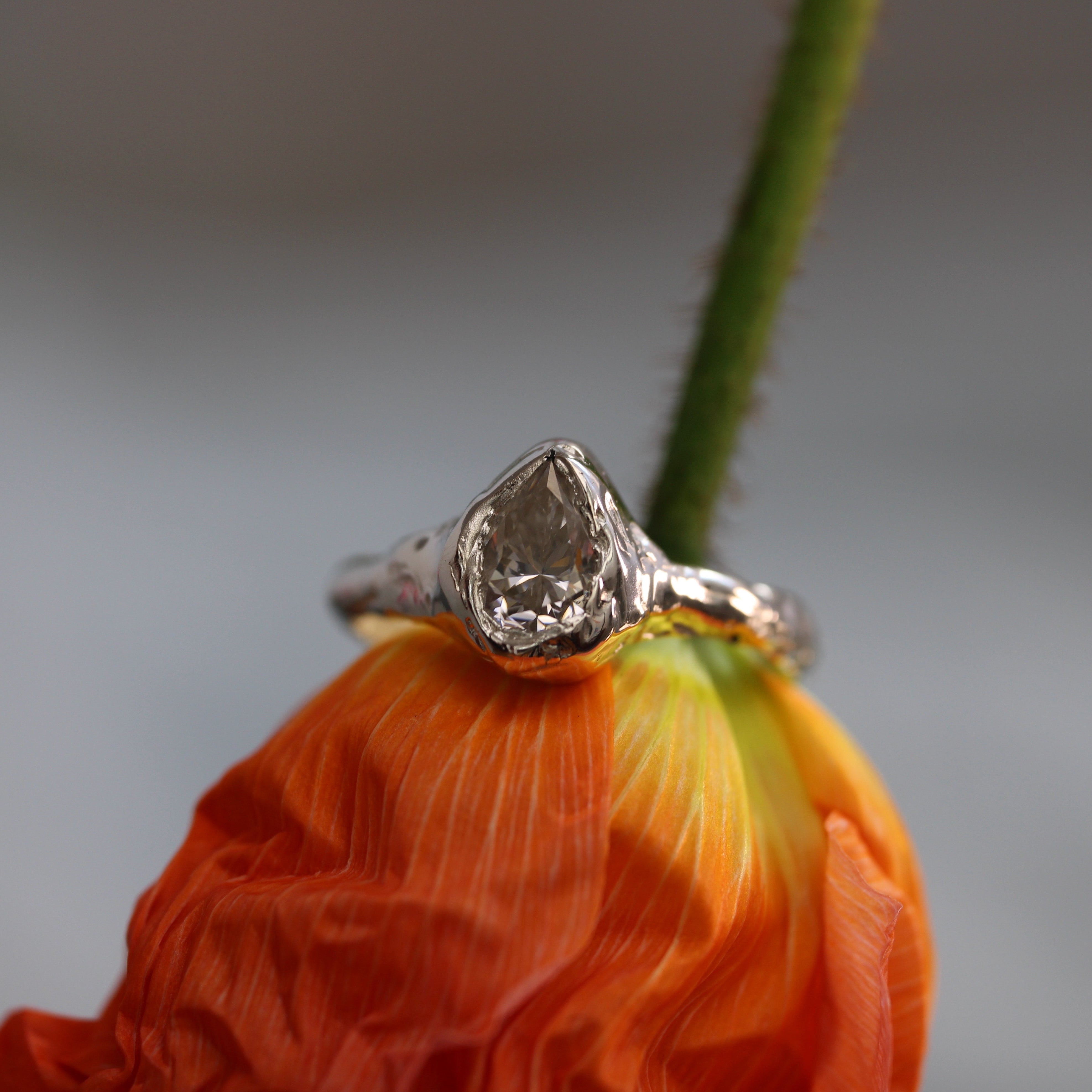 Silver ring with a diamond on an orange flower