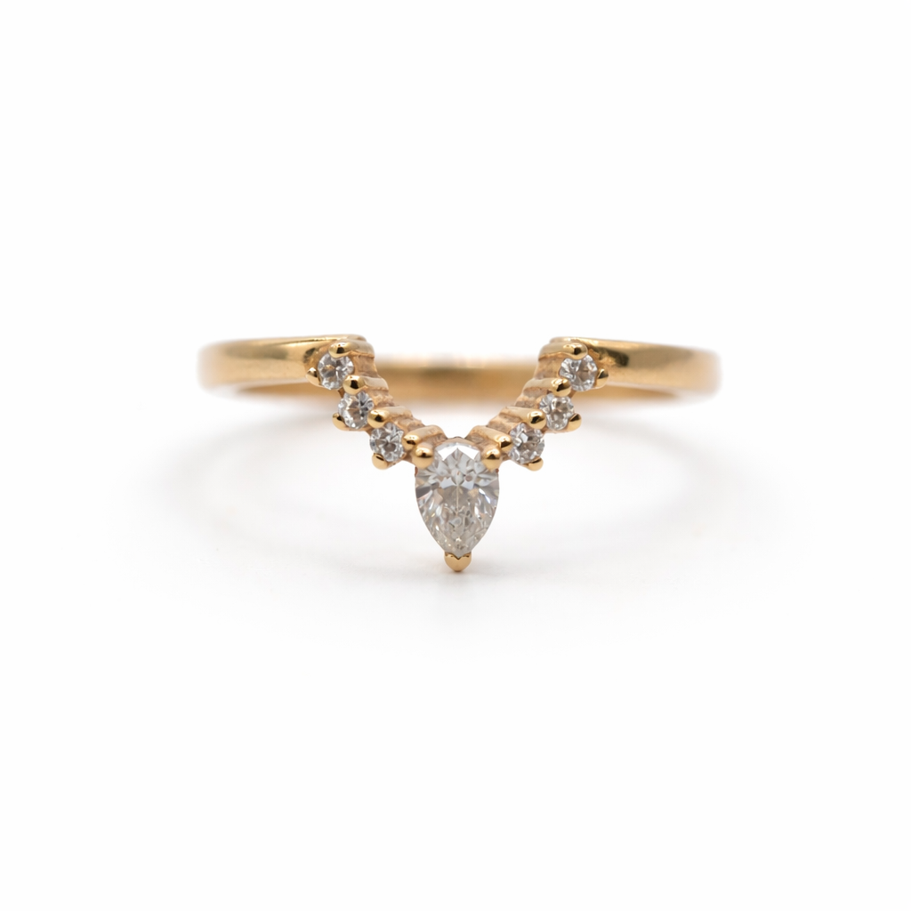 Gold ring with a pear-shaped diamond on a white background