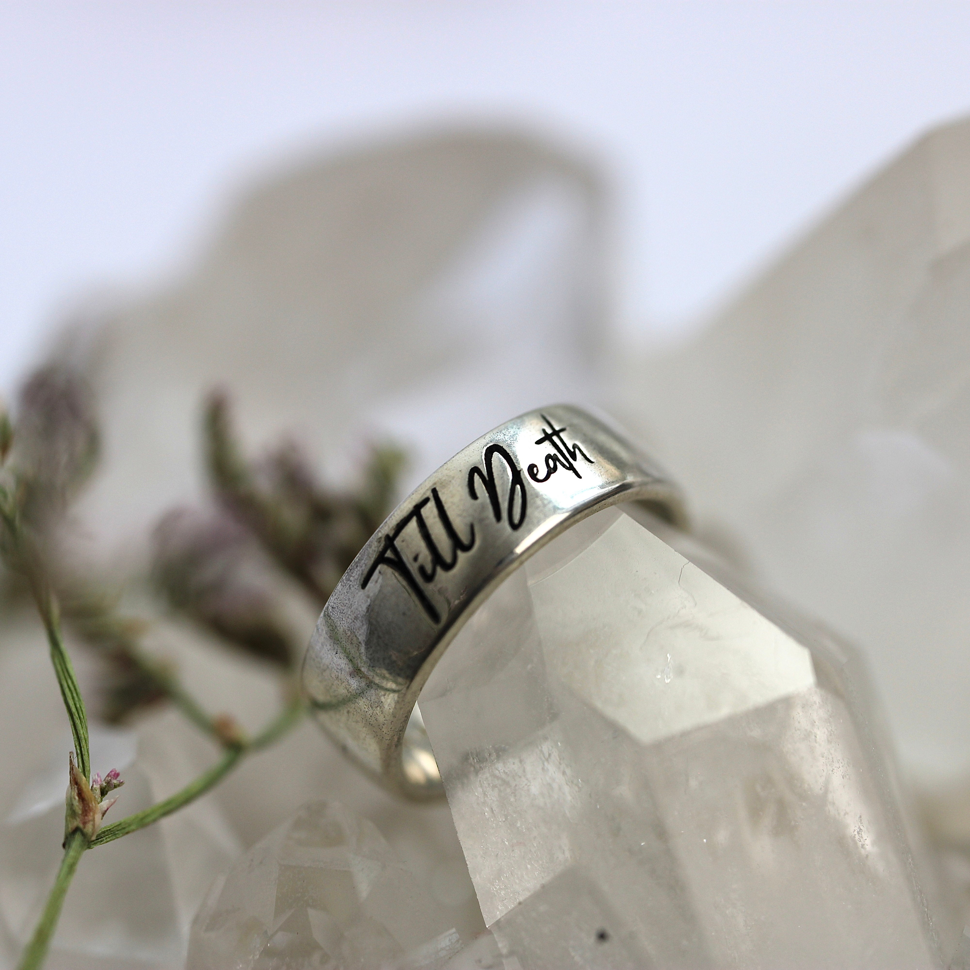 Silver ring with 'Till Death' engraving on a crystal background