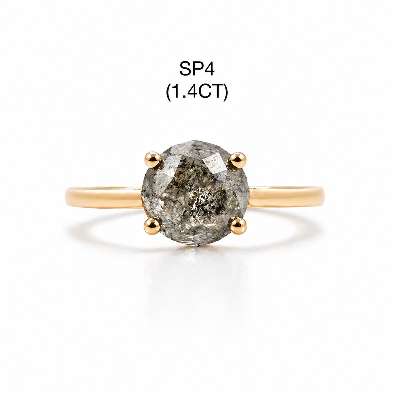 Gold ring with a salt and pepper diamond on a white background