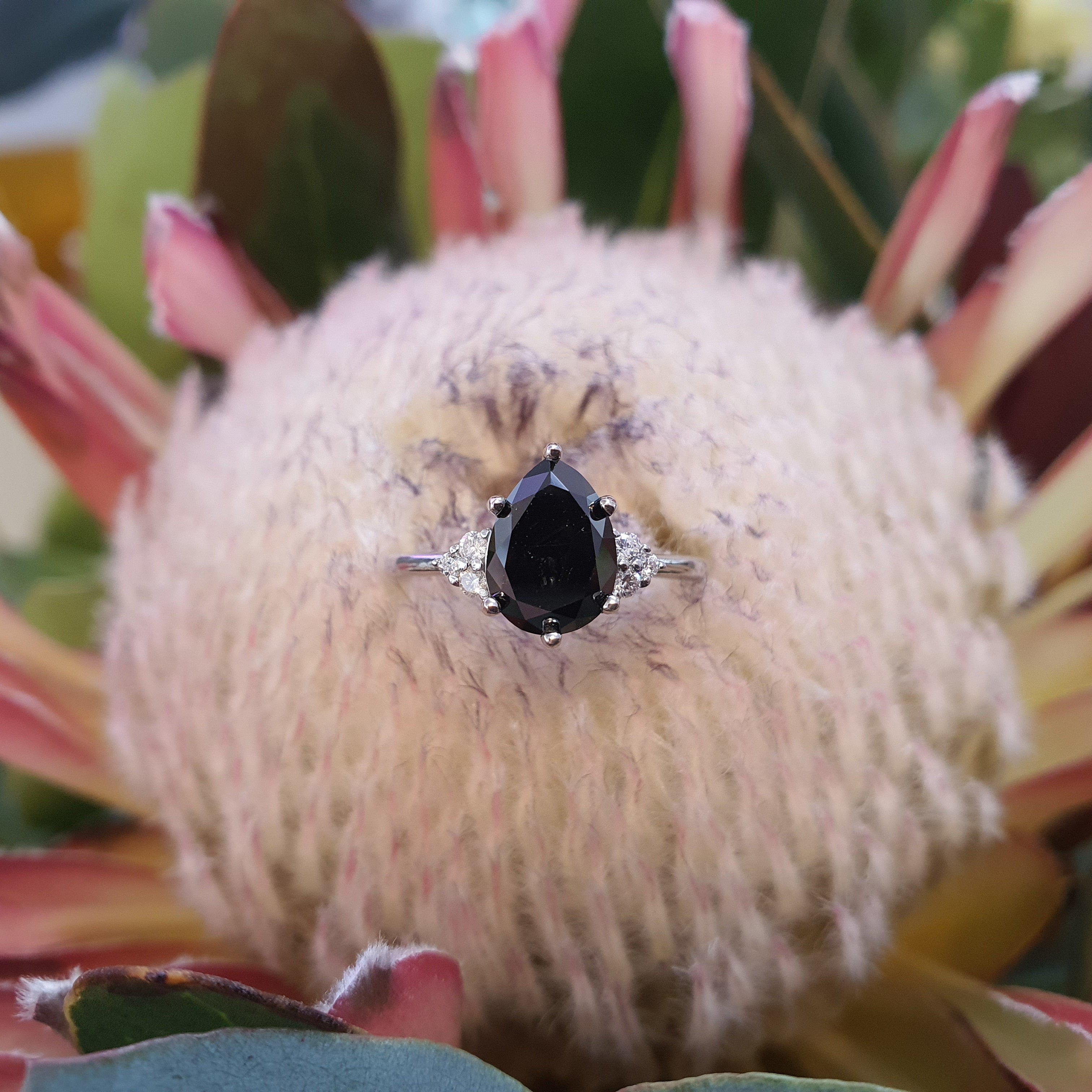 blackdiamond-ring-pear-cut-rose-gold-on flower