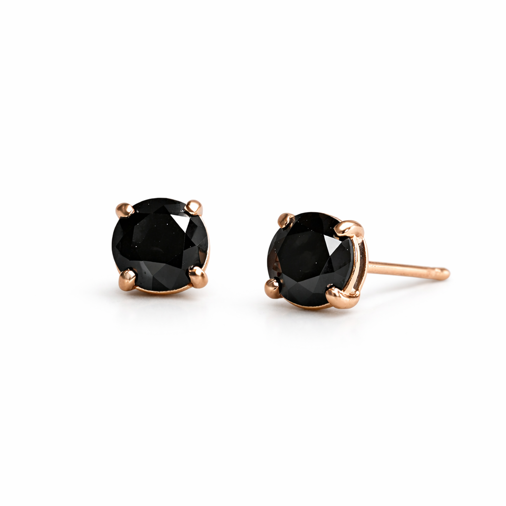 Pair of black gemstone stud earrings with rose gold settings on a white background
