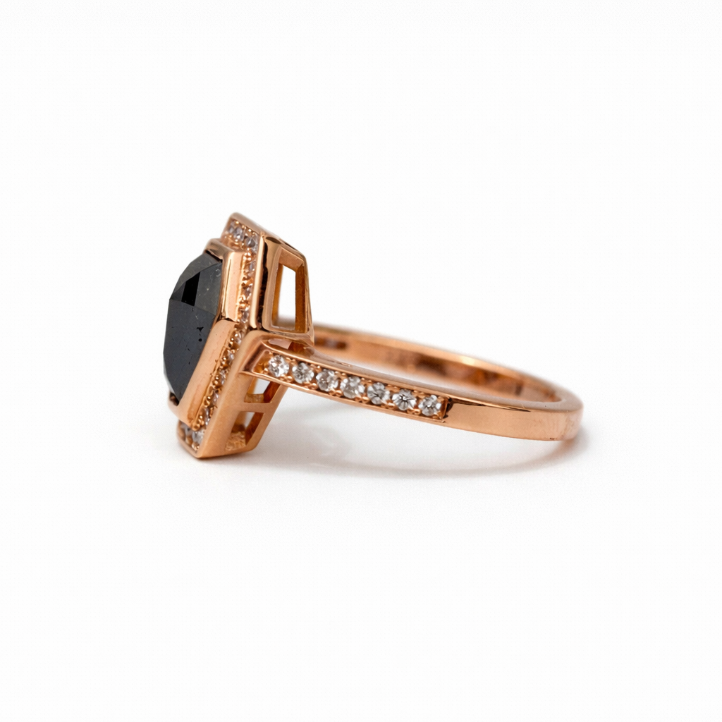 Rose gold ring with black gemstone and diamond accents on a white background
