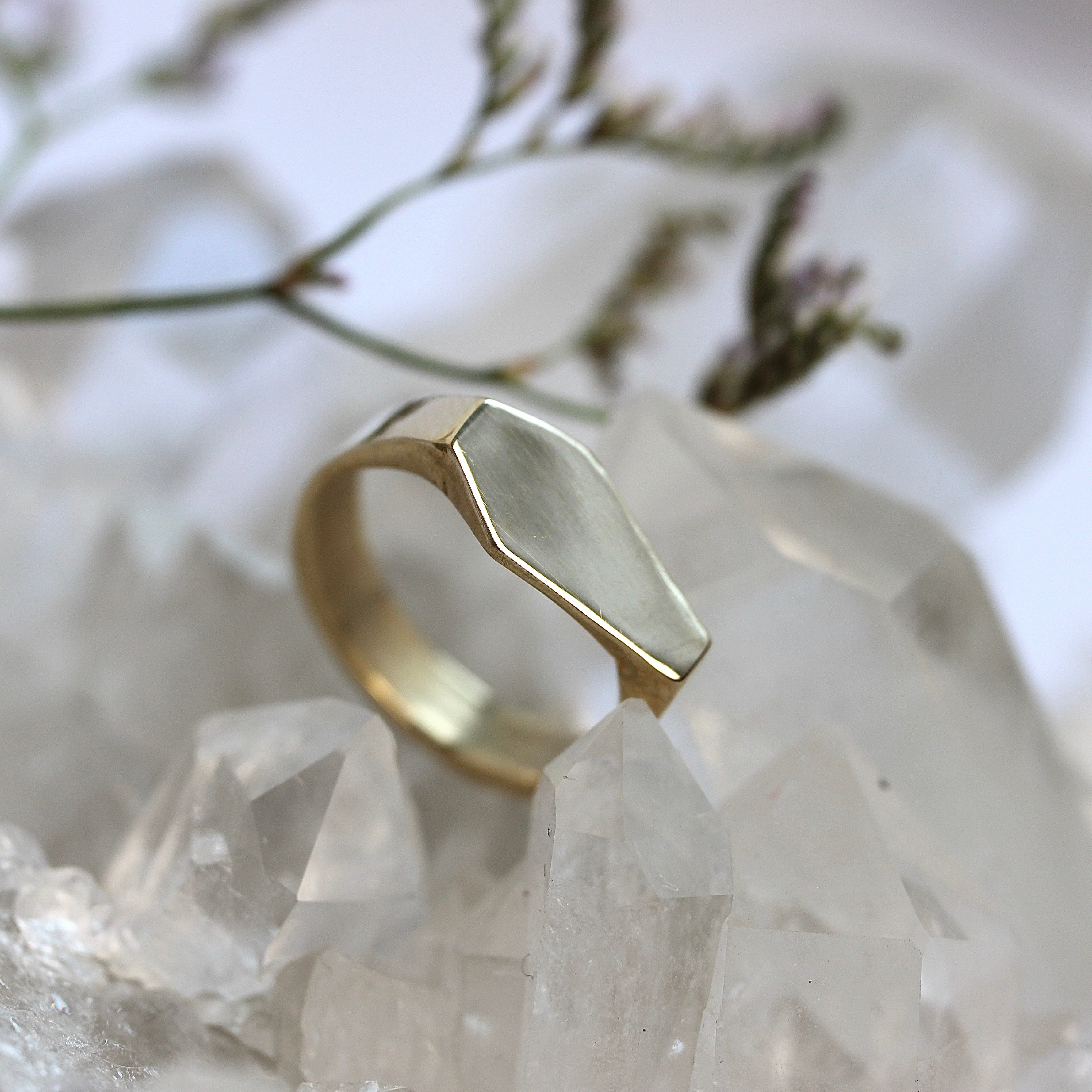 Gold ring with geometric design on a crystal background