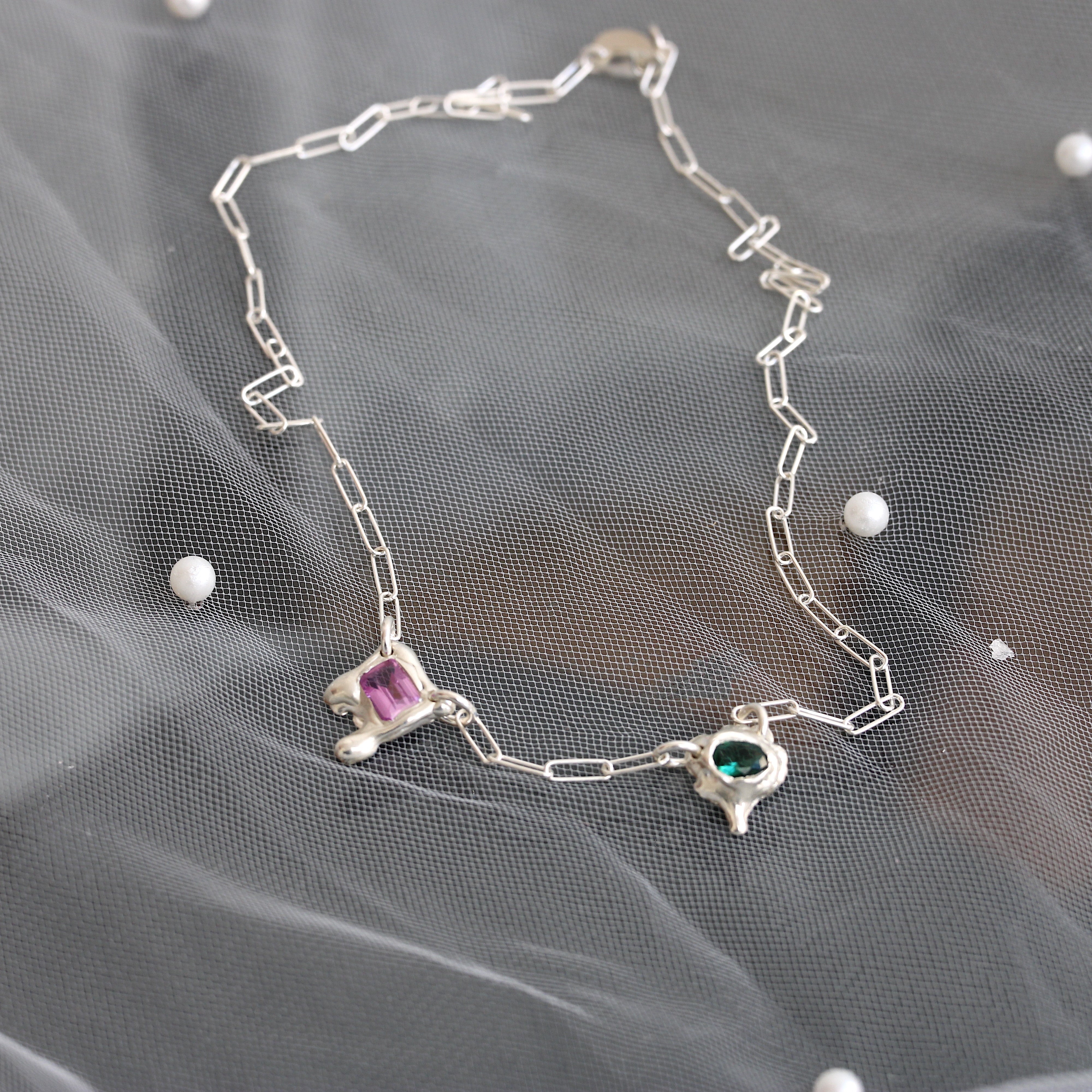 handmade sterling silver necklace with pink and green gemstones in organic molten settings on a paperclip chain