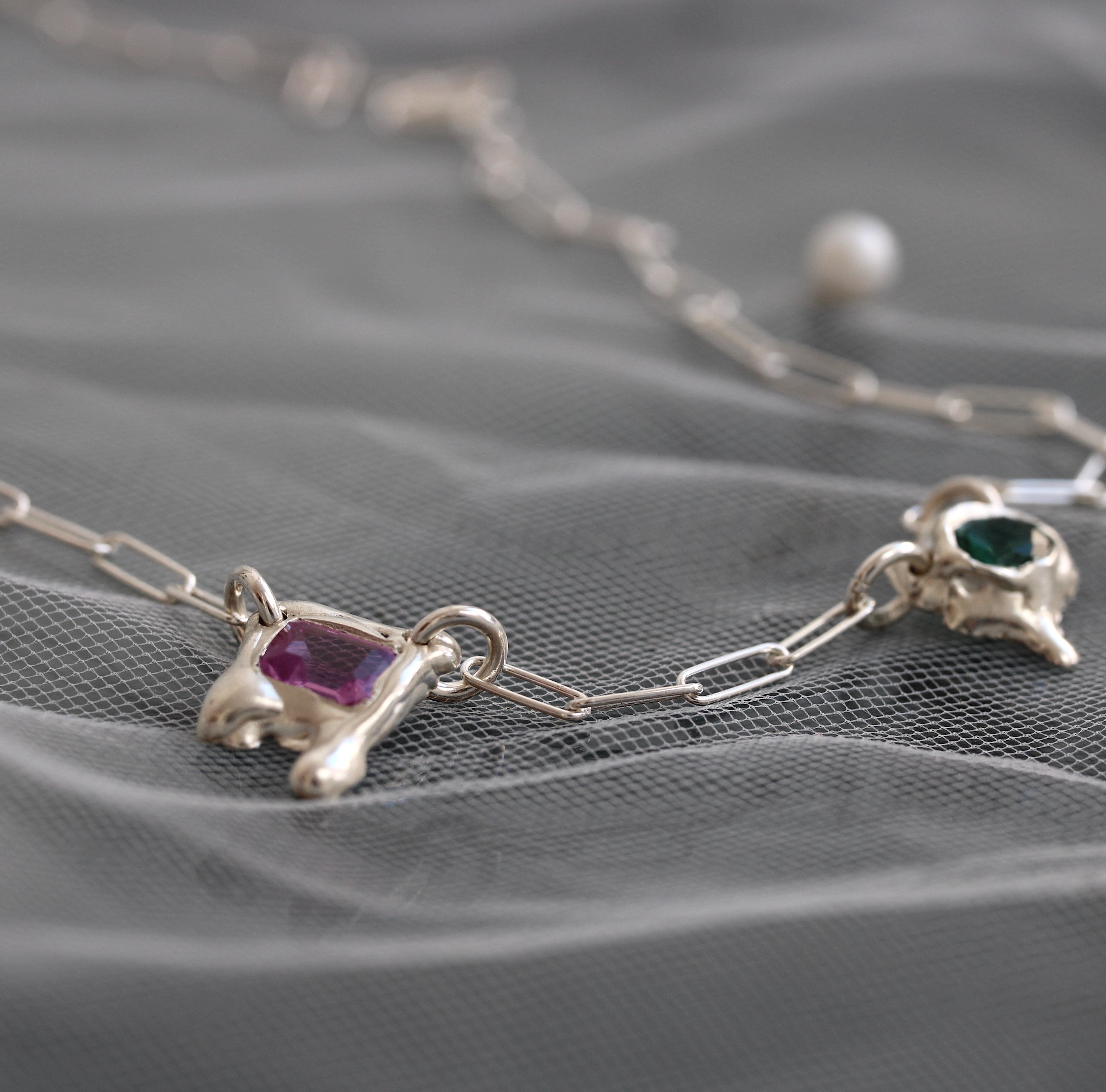 handmade sterling silver necklace with pink and green gemstones in organic molten settings on a paperclip chain