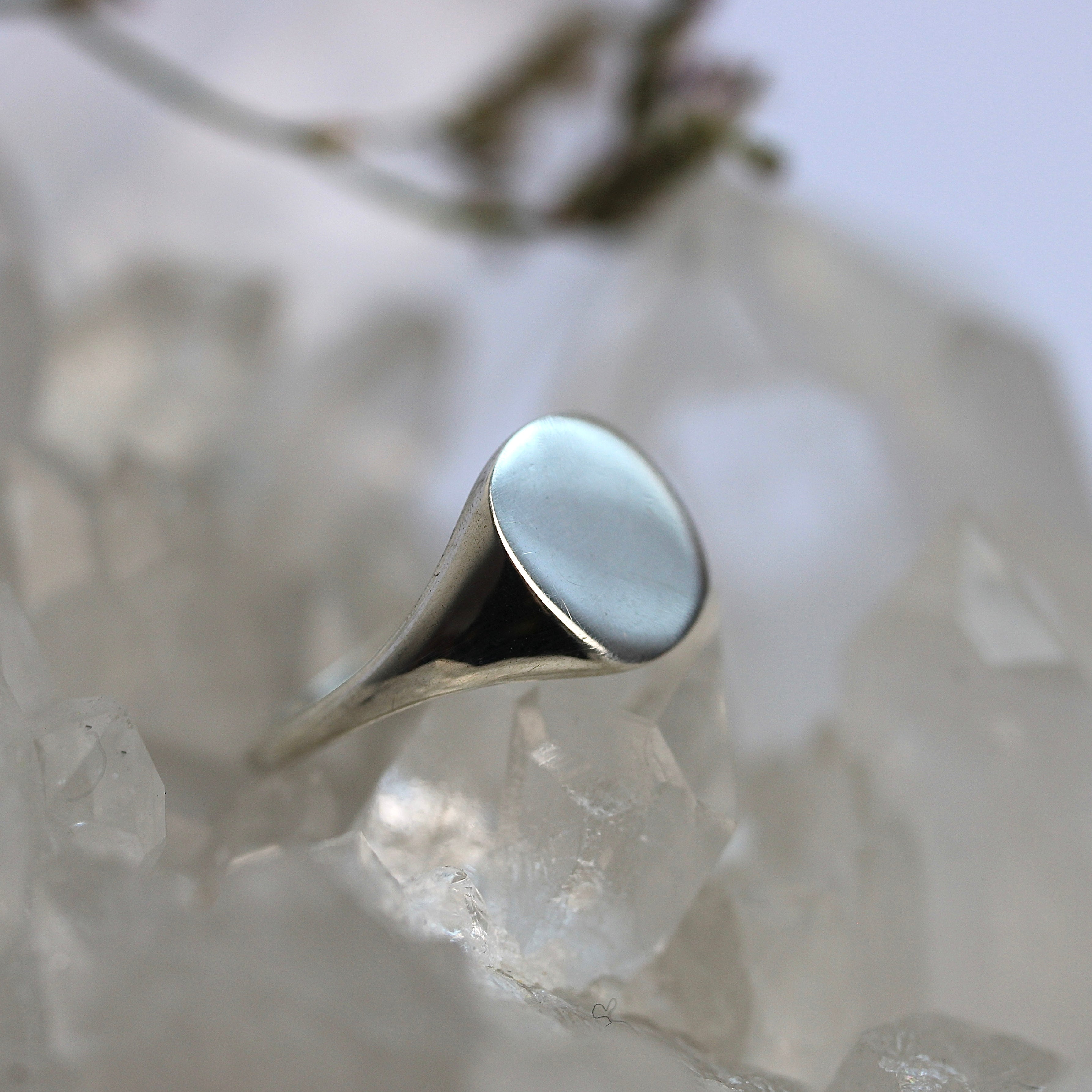 Silver ring with a light blue stone on a crystal background