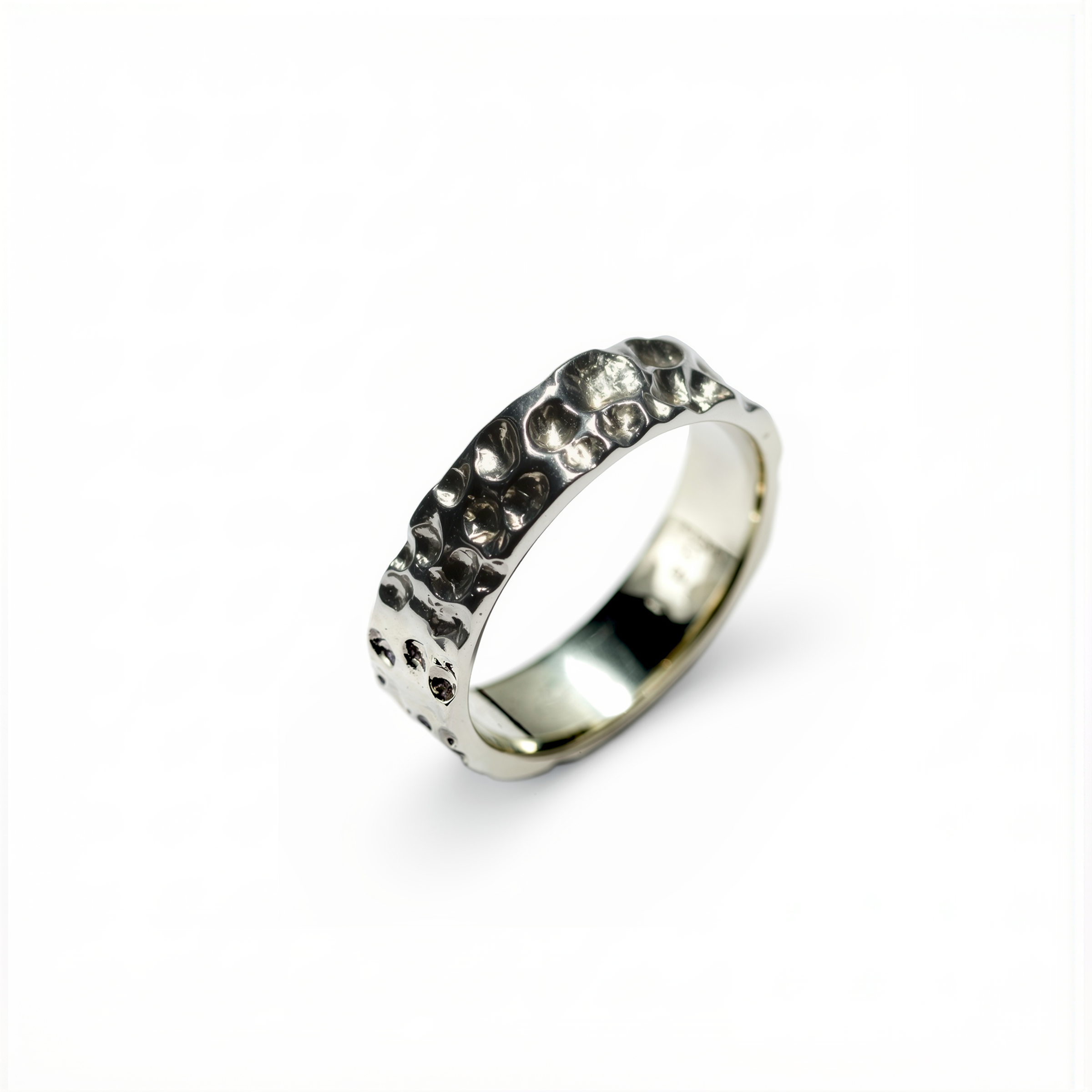 Silver ring with embedded stones on a white background