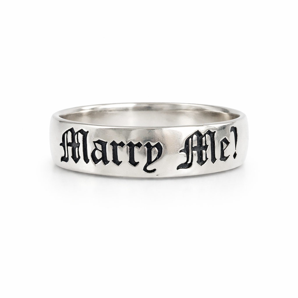 Silver ring with 'Marry Me!' engraving on a white background