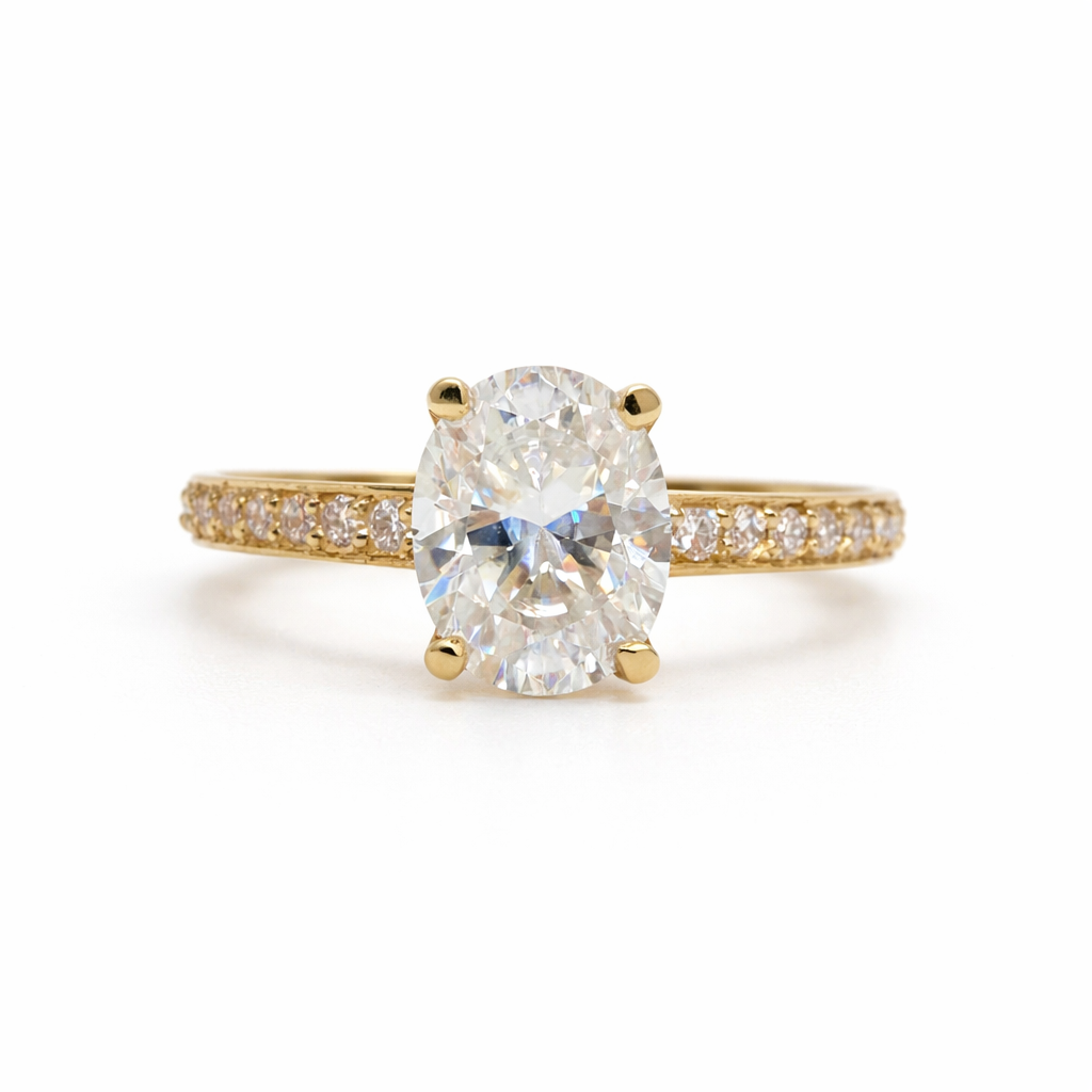 Gold ring with a large diamond and smaller diamonds on the band against a white background