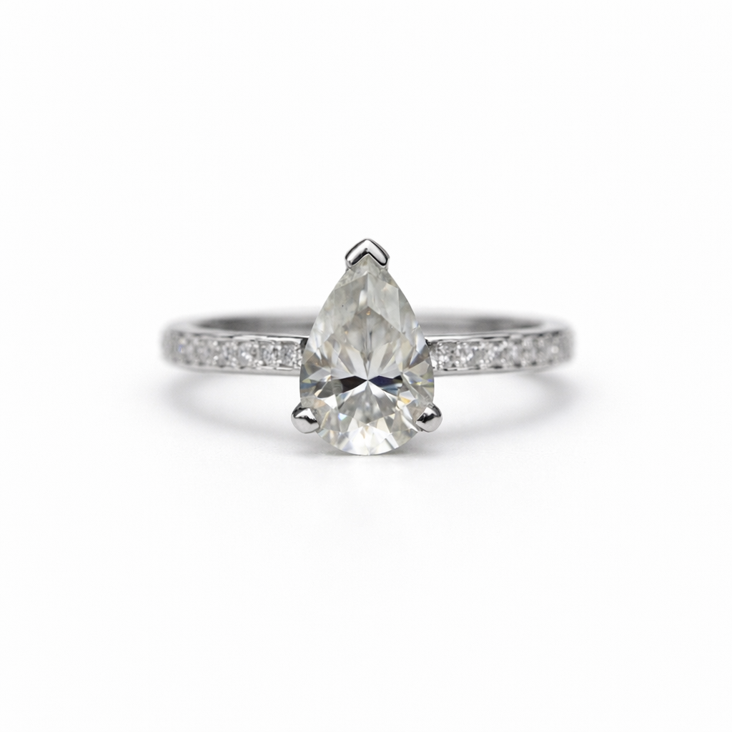 Pear-shaped diamond ring with a white gold band on a white background