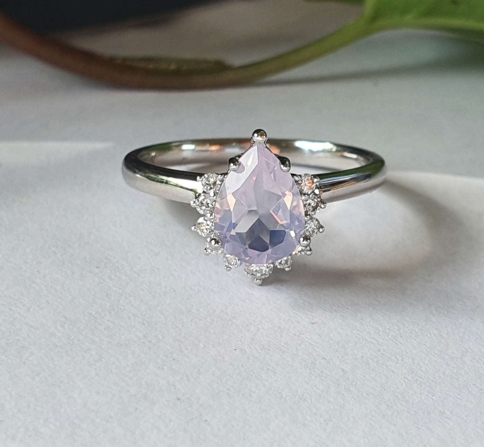 pear amina engagement ring with half halo of white diamonds