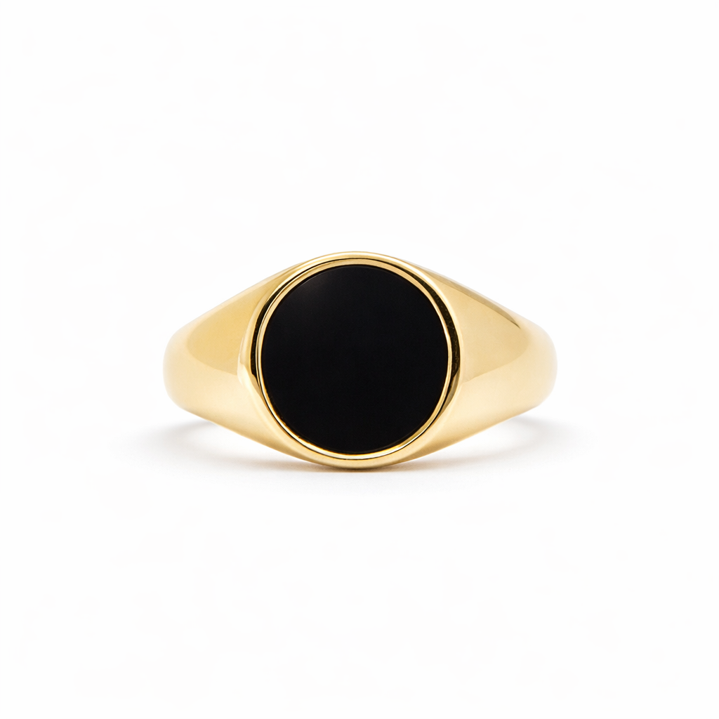 Gold ring with a black oval stone on a white background