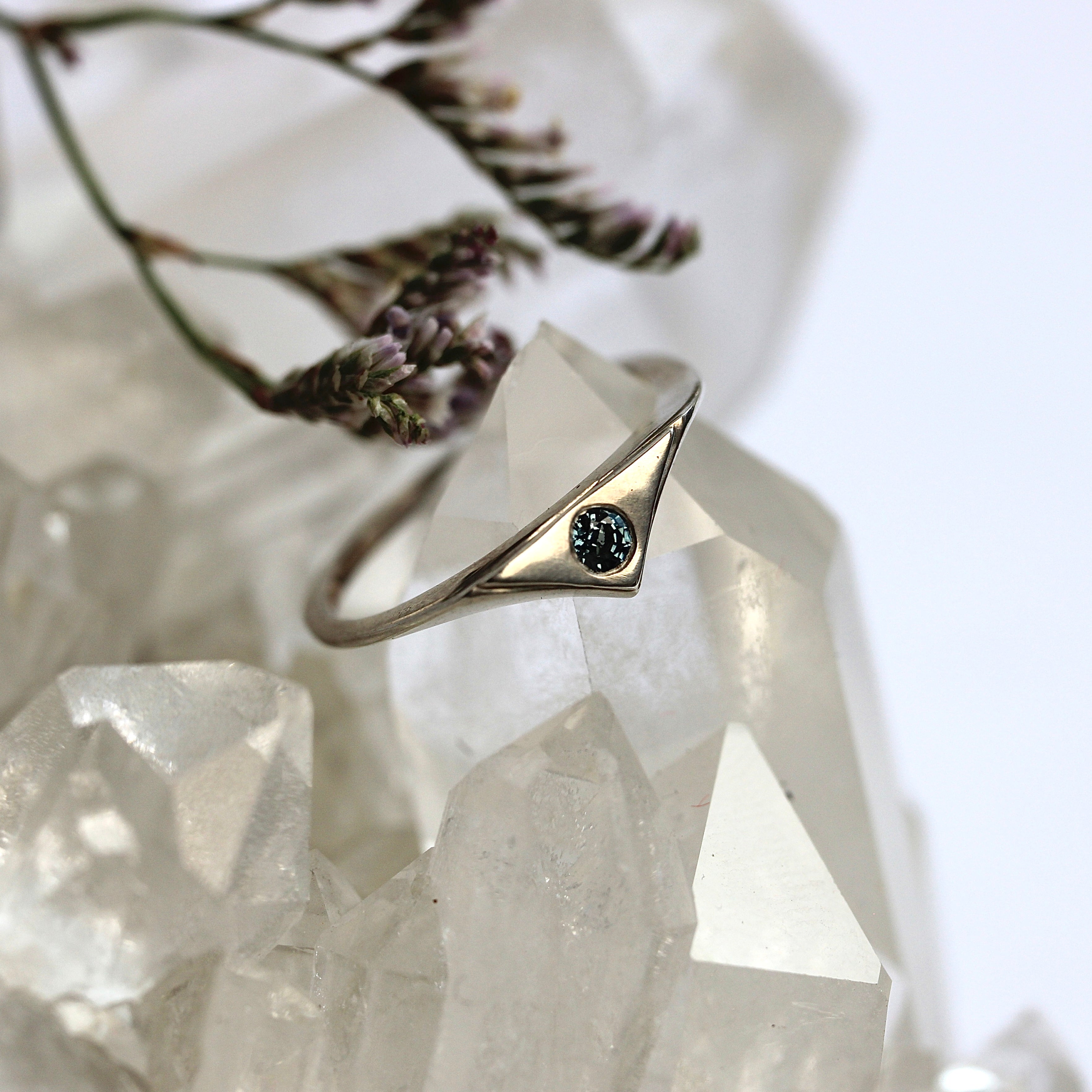 Gold ring with a black gemstone on a crystal surface