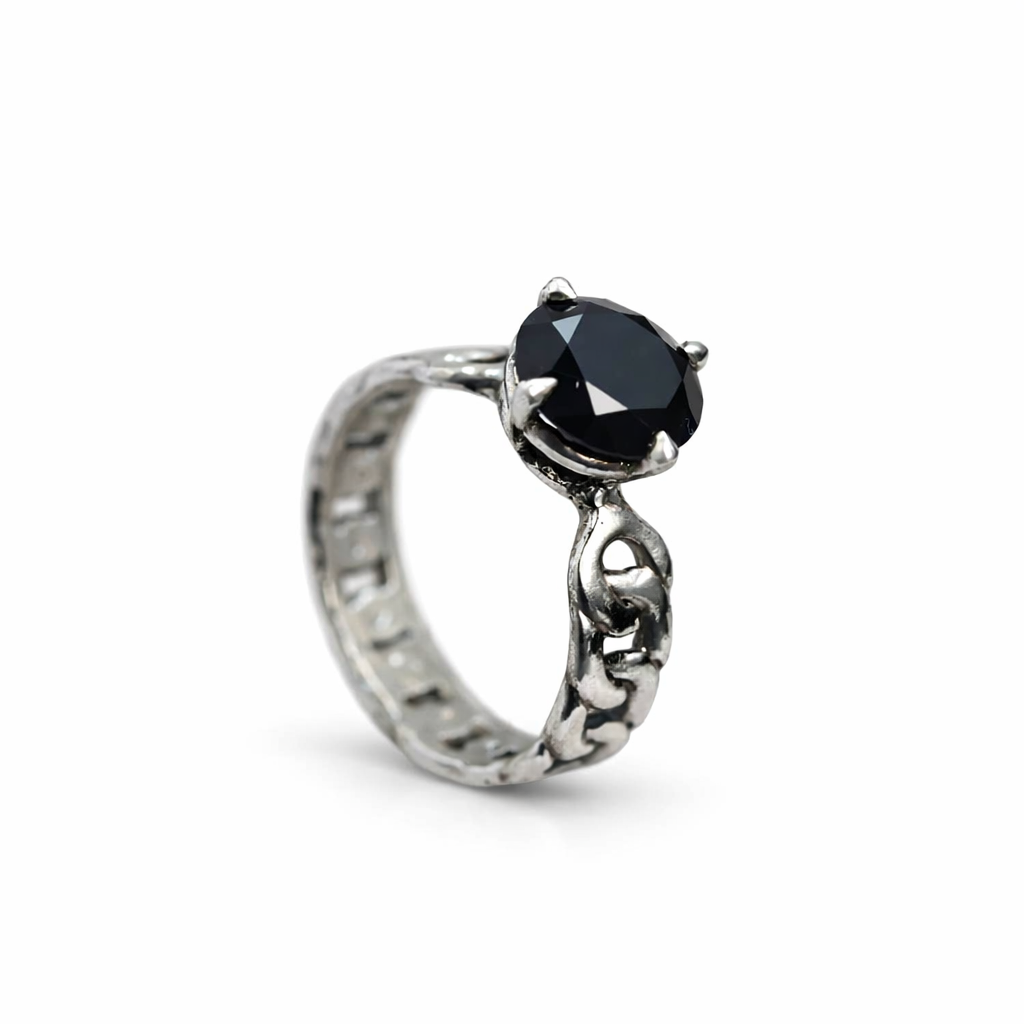 Silver ring with a black gemstone on a white background