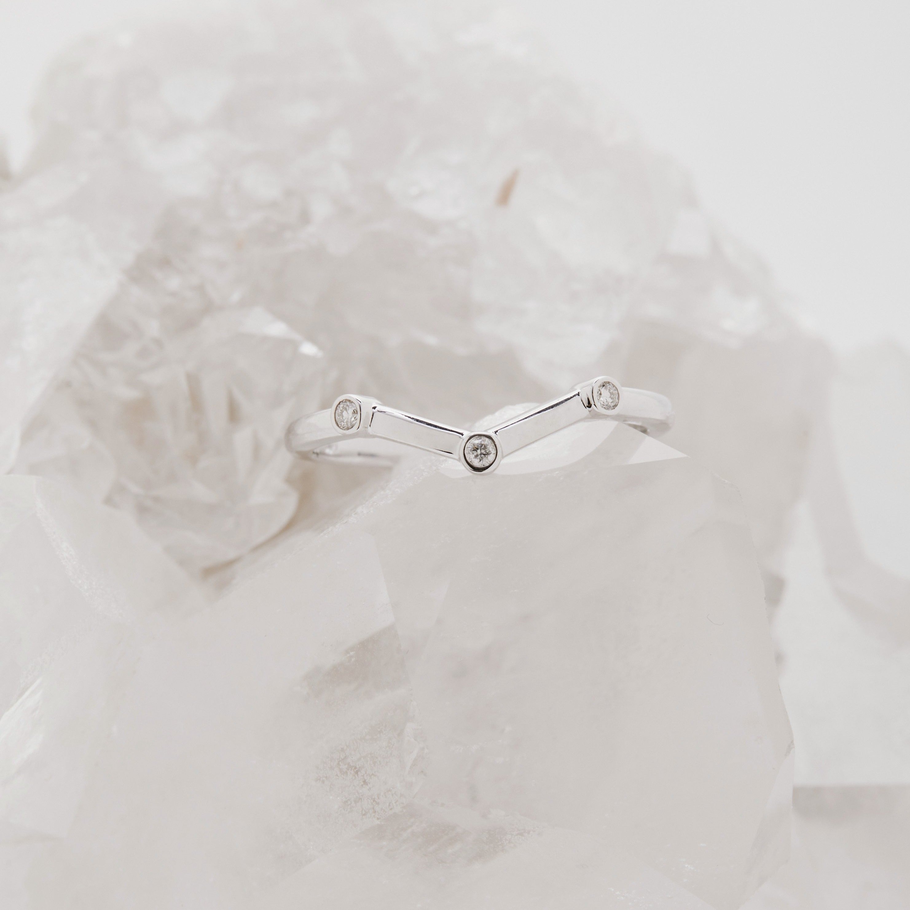Chevron shaped wedding band with flush bezel set diamonds