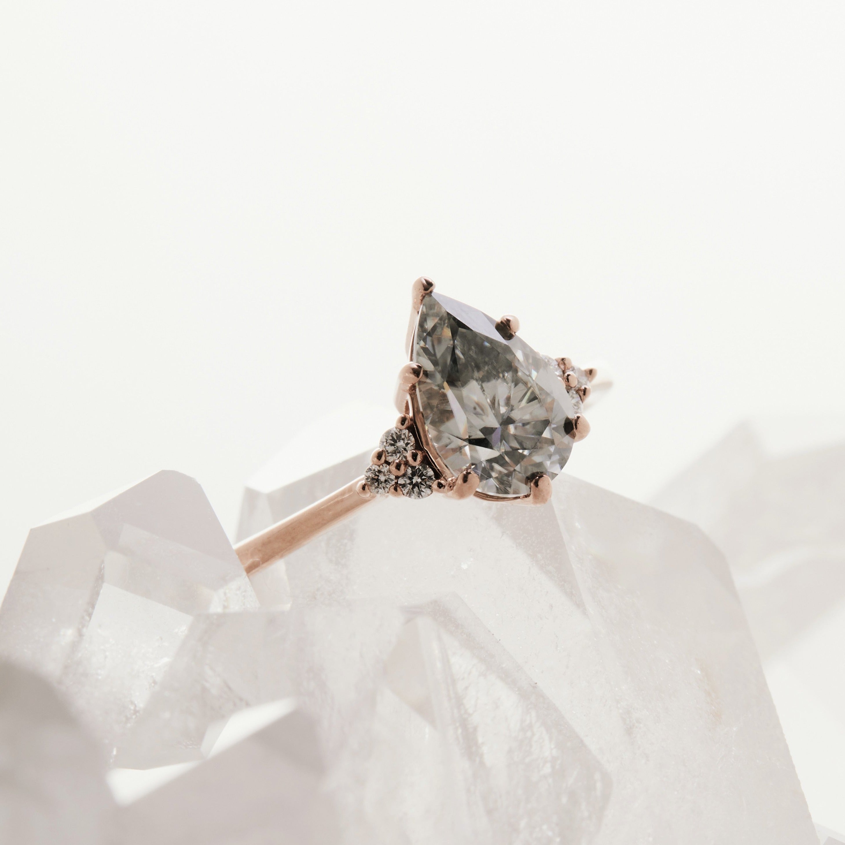 Pear-cut salt and pepper diamond engagement ring in rose gold with side stones