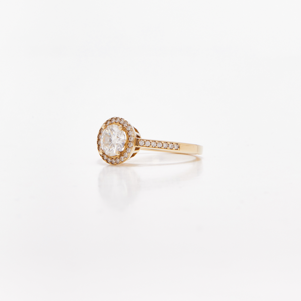 Round halo diamond engagement ring in yellow gold with a thicker pavé band, photographed on a clean white background — elegant bridal jewelry