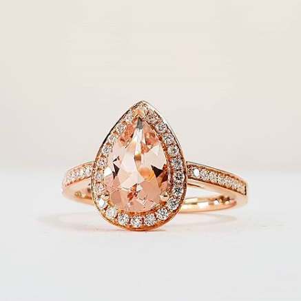Pear halo diamond engagement ring paired with matching wedding band shown on white background — classic bridal set in rose gold