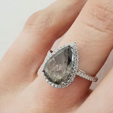 Rose gold halo diamond engagement ring with a thicker pavé band displayed on hand— romantic bridal jewellery photo