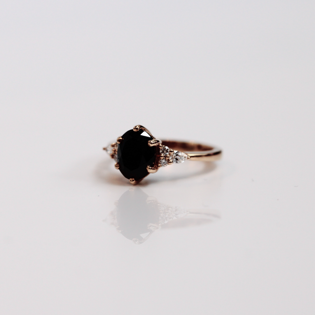 yoki oval black   diamond with pear accents on side white gold